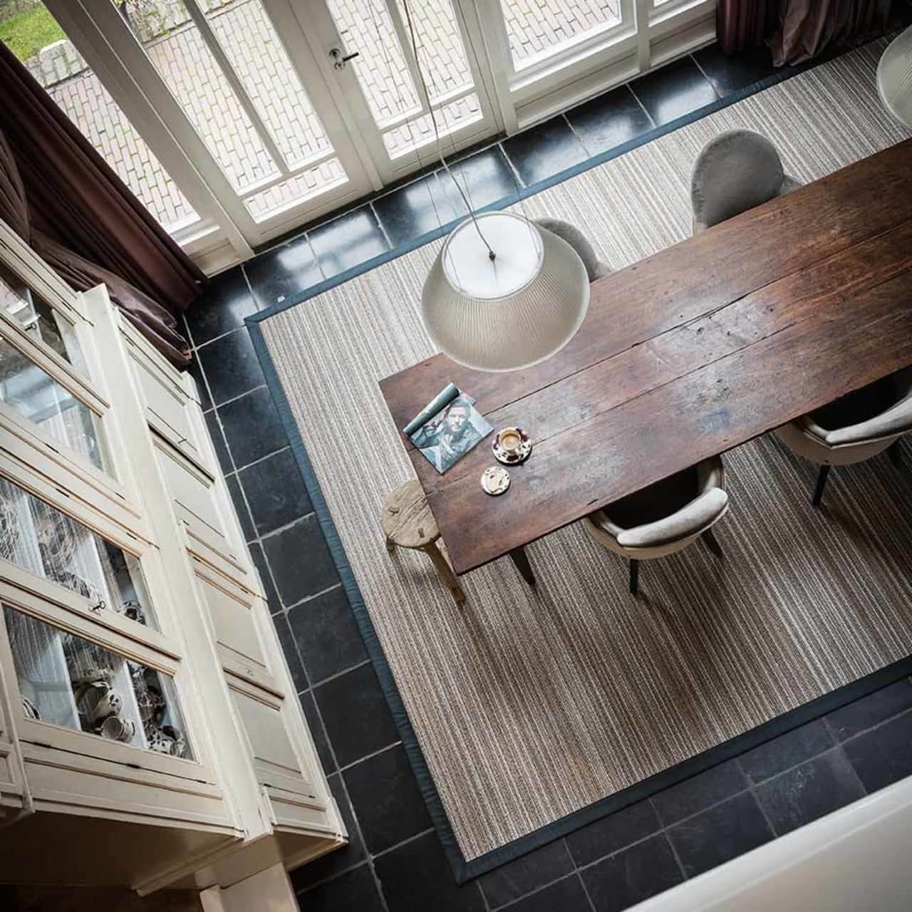 bird's eye view of large area rug in the color giraffe with black linen wrap border